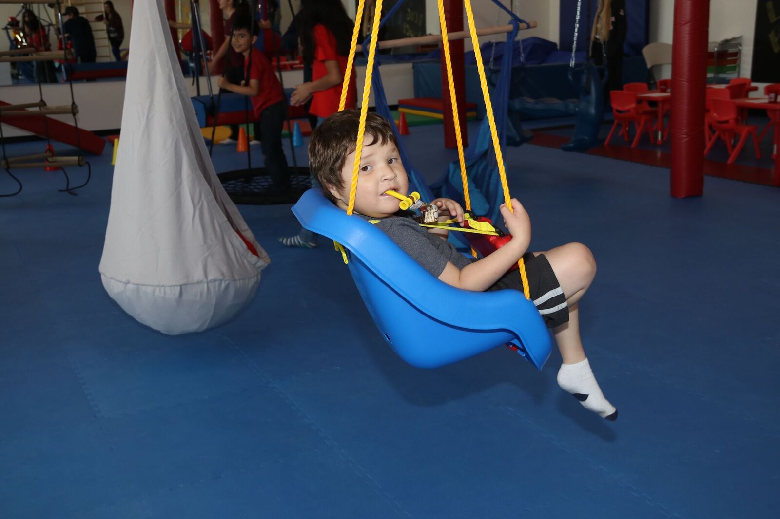 kid sitting in blue swing