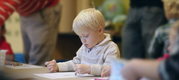 kid drawing with crayons