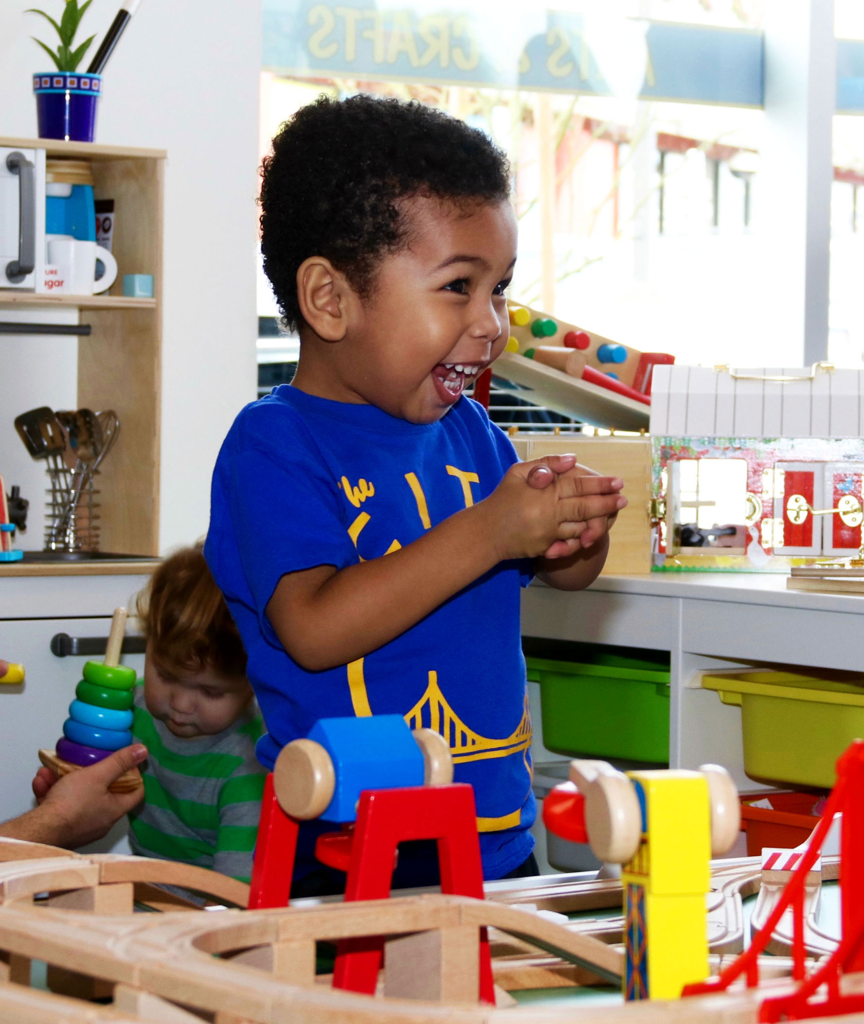 Kid smiling in front of toys