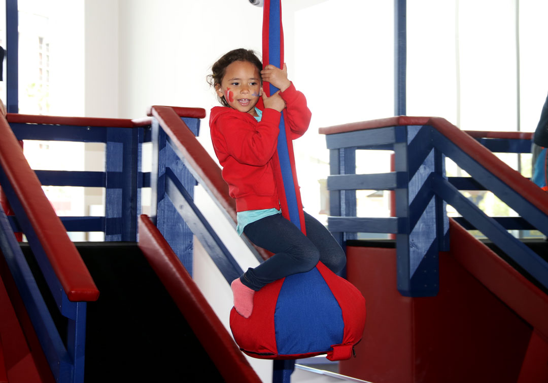 Girl with face paint riding zip line