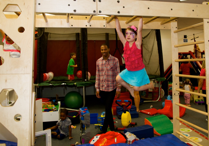 girl swinging on monkey bars