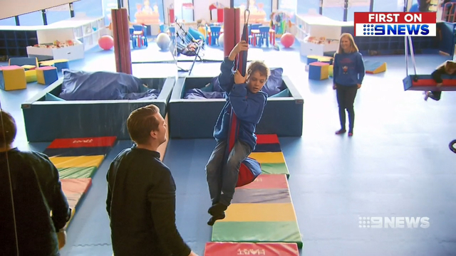 boy riding zip line indoor play gym