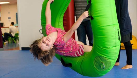 kid smiling on green triangle swing