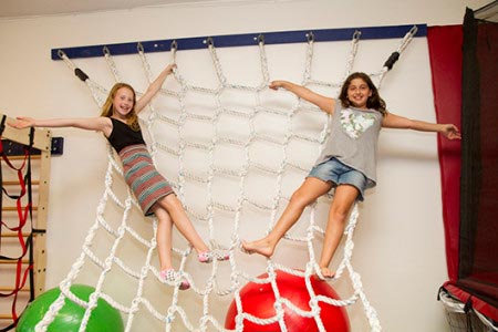 kids smiling on rope ladder