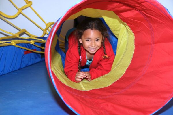 kid playing in tunnel smiling